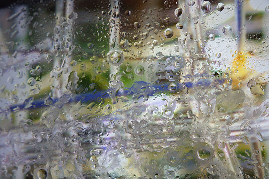 raindrops on a window with calm and serene indoor or outdoor scene featuring green and blue tones and glass materials close-up view for nature, weather, home decor.