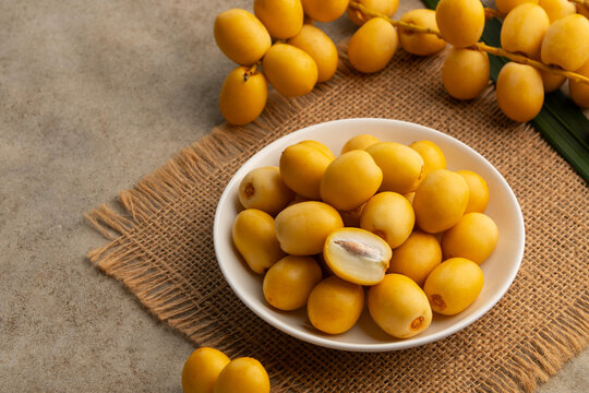 Fresh dates in white plate.raw fruits harvested straight from the palm tree without undergoing a formal dehydration process.