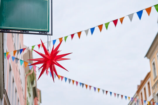 Red star decoration hanging above street with colorful festive bunting
