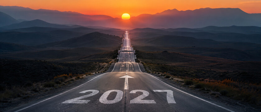 Straight mountain road marked 2027 stretches toward a vivid sunrise over layered peaks, symbolizing a new year journey, future vision, progress, ambition, opportunity and success