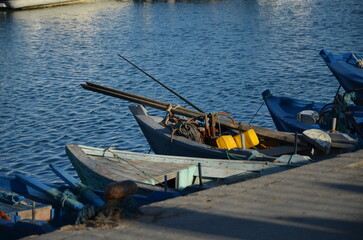 Small traditional wooden fishing boats moored at a concrete dock © beya