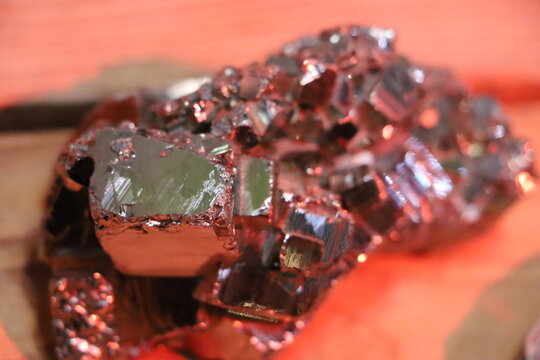 A red cuprite and green malachite mineral specimen displayed in a museum collection, showing contrasting colors and crystalline textures.