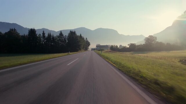First-person drive POV through Gosau, Austria on a misty morning, alpine village & mountain landscape.