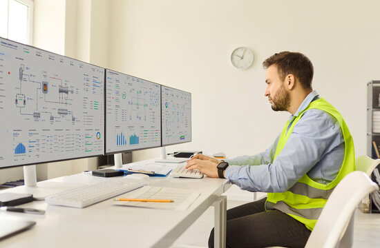 Engineer operator monitoring control systems with technology. He reviews data on multiple computer screens to improve safety and efficiency. Concept shot of industrial process monitoring.