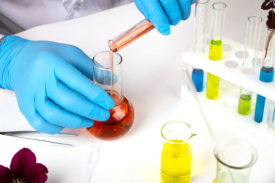 A scientist conducts an experiment in a lab with chemical solutions. A lab technician conducts a scientific experiment with solutions.