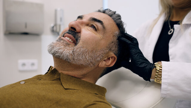 Man undergoing a trichology examination for hair and scalp health, seeking solutions for hair care and hair loss prevention