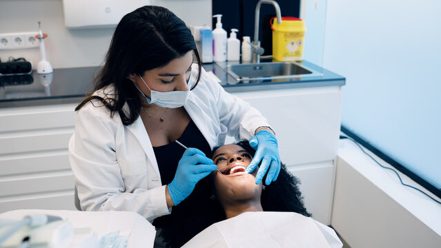 Dentist performing a routine oral examination on a patient, ensuring dental hygiene and health in a clinic setting