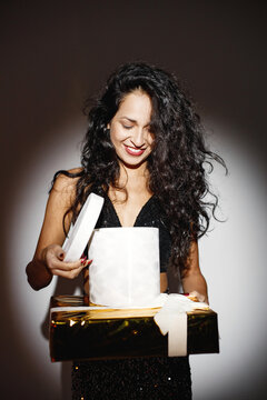 Portrait of caucasian woman holding a gifts under a projector's light