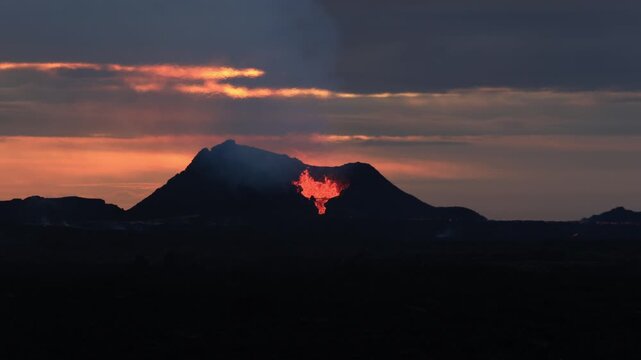 Volcanic eruption with molten lava flowing from the crater of Fagradalsfjall volcano in Iceland during a beautiful sunset