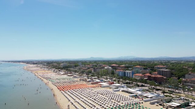 Aerial drone view of historic Porto Canale Leonardesco harbor lined with colorful boats, traditional houses and Adriatic coastline in Cesenatico, Emilia-Romagna, Italy