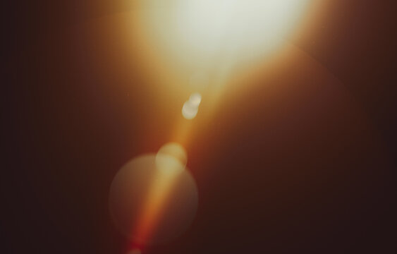 Warm Lens Flare Light Leak Background with Soft Bokeh Glow and Dark Brown Tones