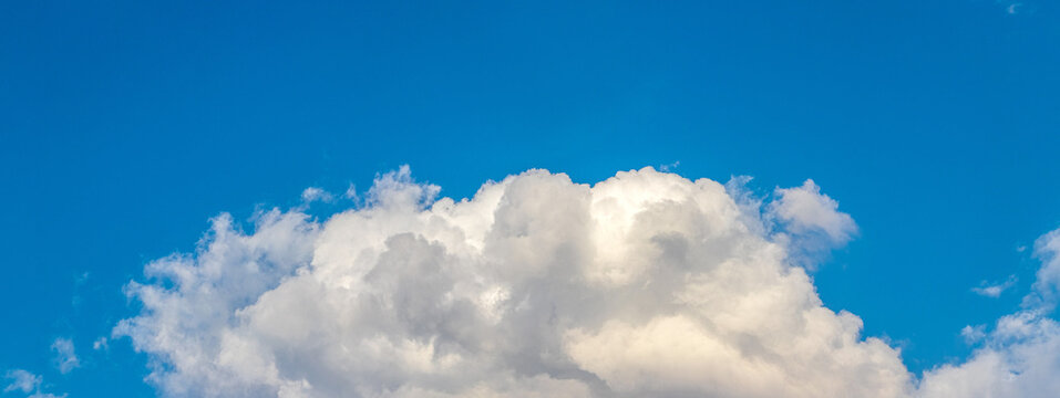 Large white cloud against bright blue sky panoramic view