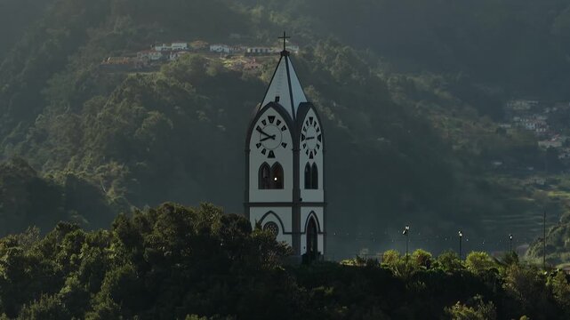 Drone aerial of Capelinha de Nossa Senhora de F&aacute;tima in S&atilde;o Vicente, Madeira, Portugal, perched on a hilltop with panoramic views of the lush valley and Atlantic coast.