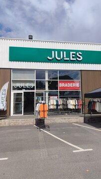 Royan, France - August 10, 2026: New Aquitaine, Charente-Maritime, Centre commercial. Jules clothing store exterior with display of shirts and signage in shopping center parking lot