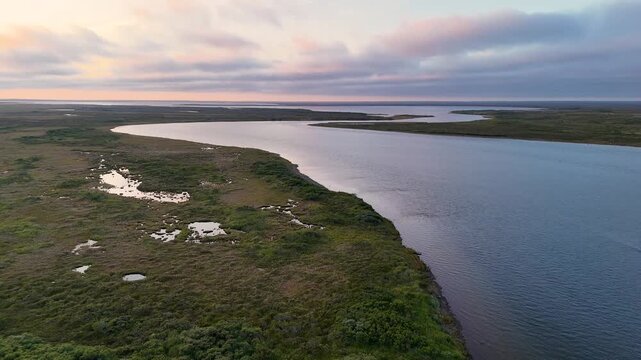 Aerial view captured by drone flying over the Egegik river in Alaska. The Alaskan water is near Bristol Bay and the sky is colorful during the sunset. 
