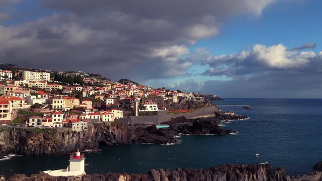 Drone aerial of the Bay of C&acirc;mara de Lobos, a charming fishing village on the south coast of Madeira, Portugal, with colorful boats, waterfront and dramatic cliffs.