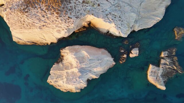 Aerial drone view slowly rising above unique coastal rock formations on Mandrakia, Milios, Greece. 