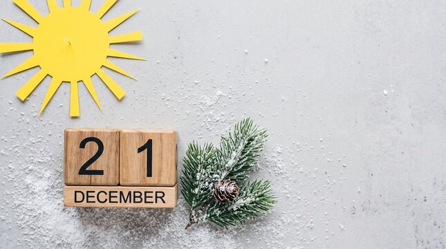 December twenty first wooden calendar blocks with festive snowy pine branch and yellow paper sun icon on concrete texture for winter solstice seasonal concepts.