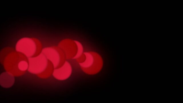 Abstract red bokeh lights on a dark background creating a soft, glowing, and mysterious visual effect.