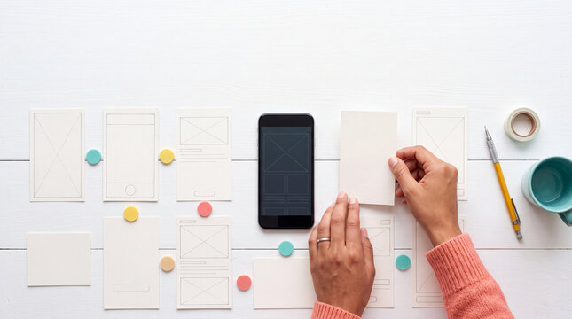 Mobile Game UX Designer Arranging Interface Wireframes