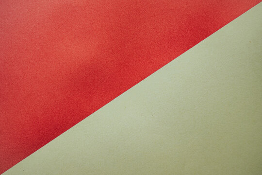 Red and green textured paper sheets arranged diagonally, showcasing a smooth surface and subtle grain patterns, ideal for backgrounds or craft projects