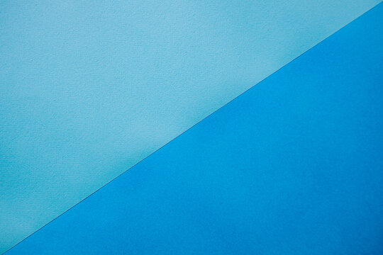 Two-tone blue textured background with a diagonal split, featuring light blue and dark blue surfaces creating a visually appealing contrast for design purposes