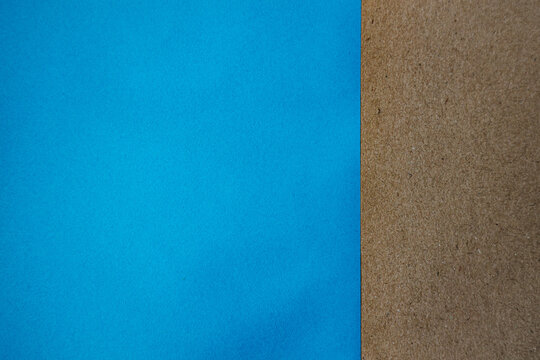 Blue and brown textured paper sheets arranged side by side, showcasing contrasting colors and materials, suitable for design and craft projects