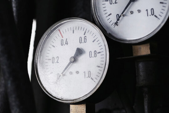 Round analog pressure gauges with numbered scales and metal casings. Industrial measuring instruments for machinery control engineering monitoring maintenance equipment and technical background.