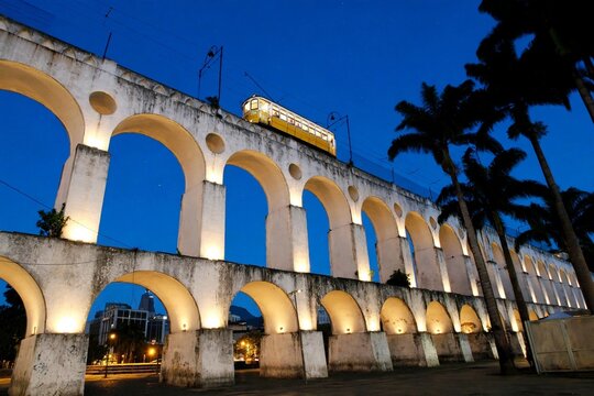 Lapa Arches illuminated at night with Santa Teresa tram in middle Rio