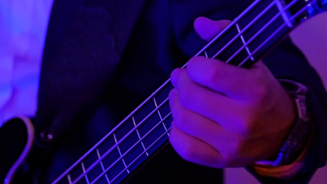 Guitarist plays the guitar. A musician in a musical group on stage gives concert