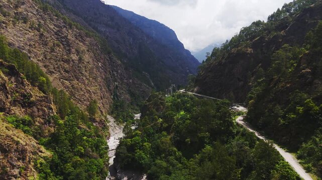 Rasuwagadhi, Rasuwa, Nepal - 29 August 2026: Aerial view of the Trishuli river flowing through a deep mountain valley with a winding road along steep forested slopes.