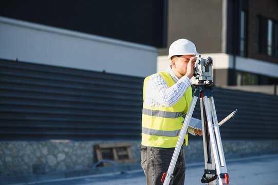 Surveyor working with total station at construction site