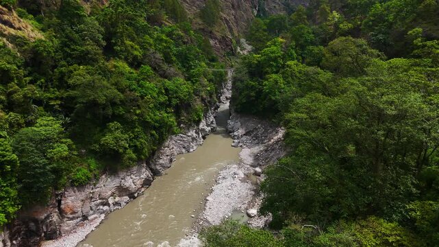 Rasuwagadhi, Rasuwa, Nepal - 29 August 2026: Aerial view of the Trishuli river flowing through a lush green mountain valley with rocky banks.