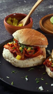 Homemade Mexican cemita filled with spiced al pastor meat, cilantro and pineapple