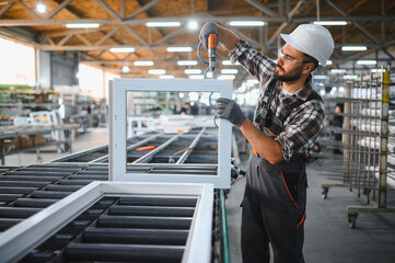 Fototapeta premium Worker assembling plastic pvc window frame in factory