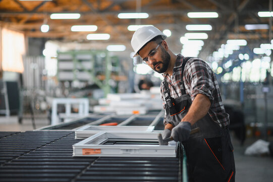 Worker assembling pvc window frame in factory