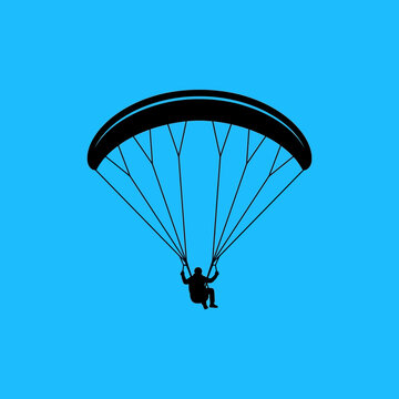 Silhouette Of A Paraglider Soaring Through The Bright Blue Sky
