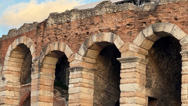 Detail of stone arches and brick facade of Verona Arena in Italy