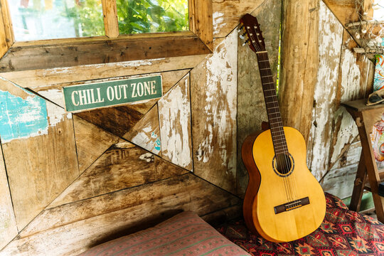 Cozy chill out zone with acoustic guitar, cushion, and rustic wooden wall