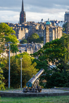 Historic cannon overlook Edinburgh cityscape at sunset, Scotland