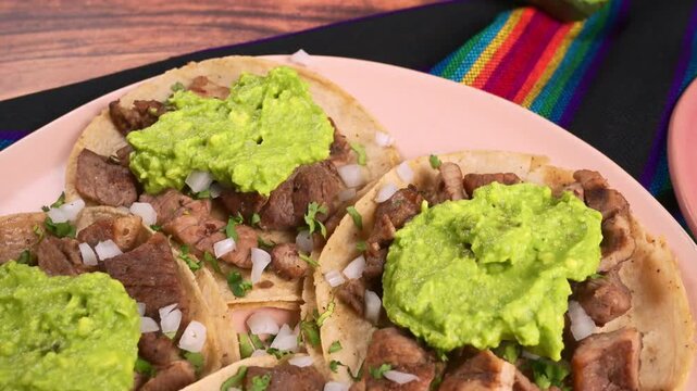 Aerial view of authentic Mexican carne asada tacos topped with fresh guacamole