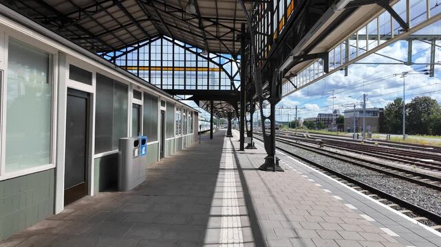 Covered platform at Hengelo railway station in the Netherlands with steel roof structures, glass windows, and tracks leading outside.Hengelo, Netherlands 29.07.2026