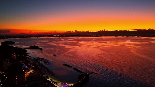 Aerial view of the vibrant sunset over the ocean and the coastline at Dusit Thani Mactan Cebu in Lapu-Lapu, Central Visayas, Philippines.