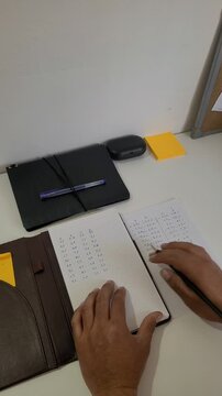 A person writing in their planner, focused on their projects and jotting down numbers and text