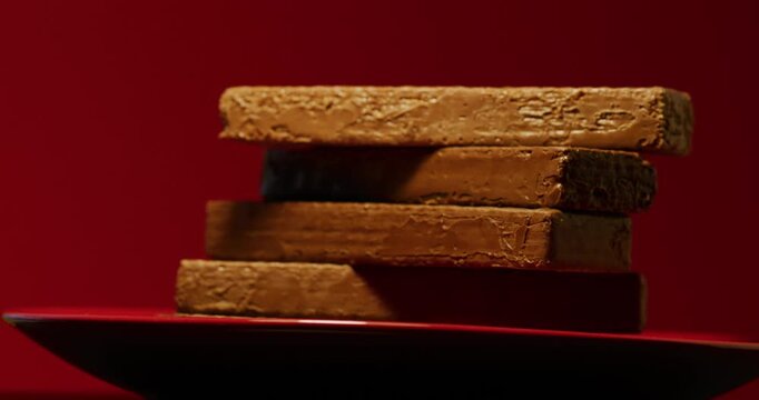 Chocolate waffles on a red plate and a red background. Сonfection, sweets and candies. Tasty and delicious food.