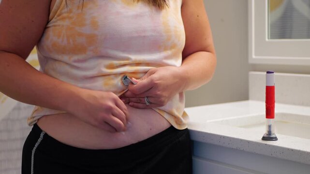 Middle aged female providing GLP1 shot in stomach for weight loss, obesity, diabetes, weight management - Expensive pharmacueticals game changing meds