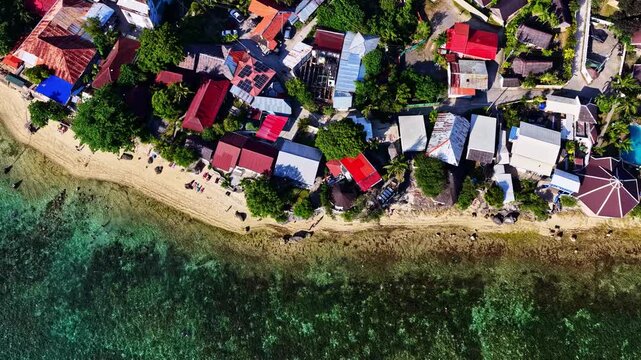 Aerial view of coastal houses and turquoise waters along the beach in Moalboal, Central Visayas, Philippines.