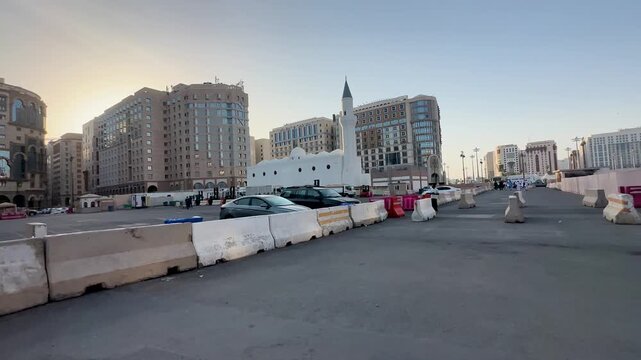 Street view of Ali Bin Abi Talib Mosque and modern Medina buildings.