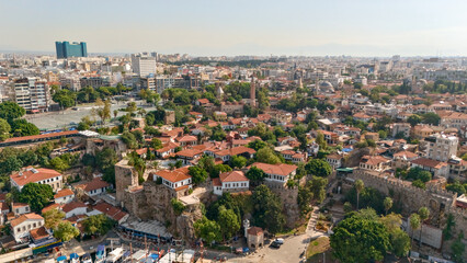 Fototapeta premium Aerial panorama over Antalya's Kaleici old town with red tile rooftops, historic stone walls, mosque minarets and the modern cityscape of Turkey