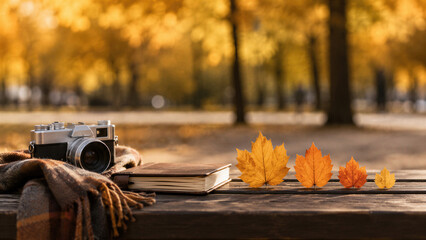 Naklejka premium Vintage camera with notebook and plaid blanket on wooden bench with autumn maple leaves in park. Family leisure and travel memories concept. Fall season outdoor activity.